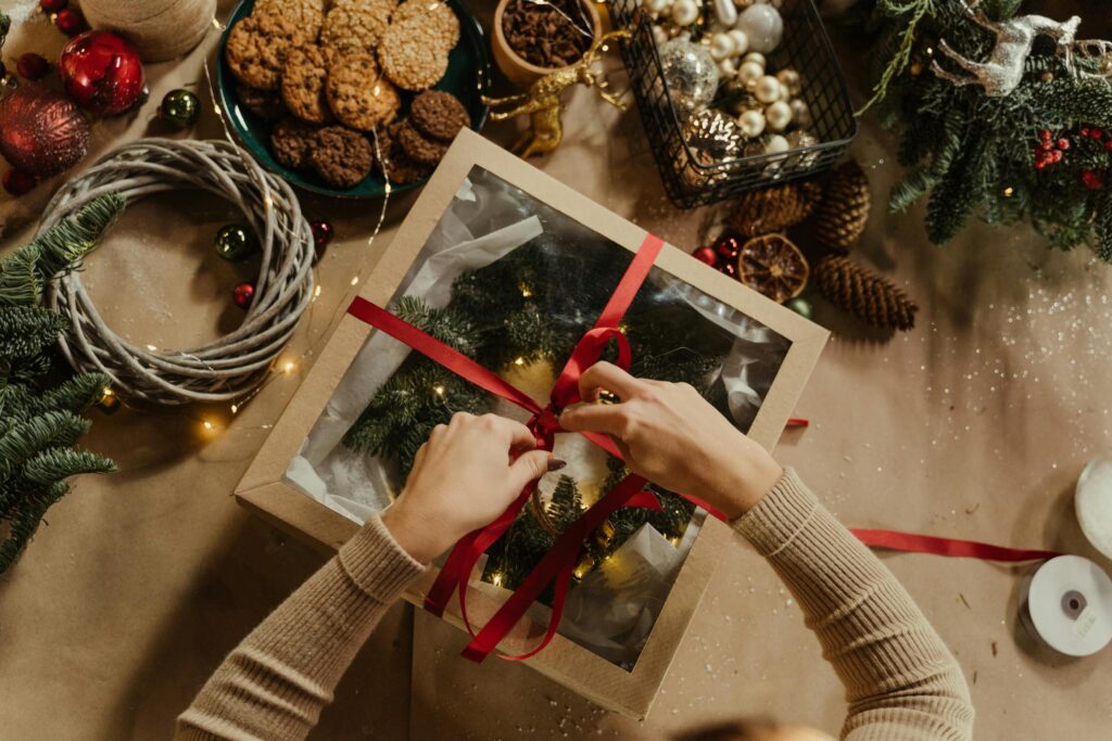 pexels-photo-6063706-6063706 Top view of a Christmas gift wrapping scene with cookies, baubles, and festive decorations.